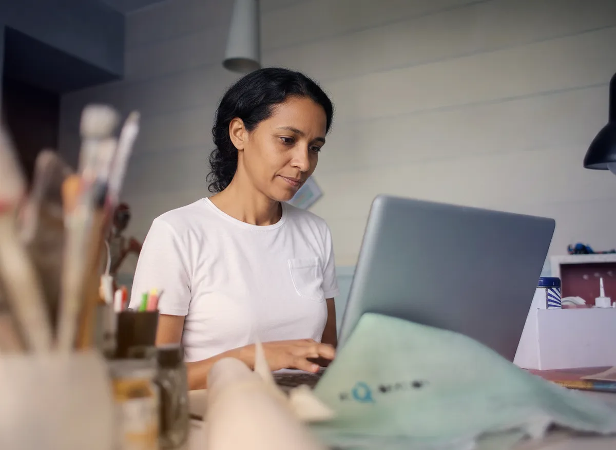 Small-business owner at her own counter, laptop open